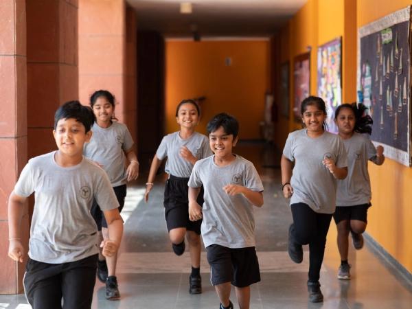 Students running in a corridoor on campus.